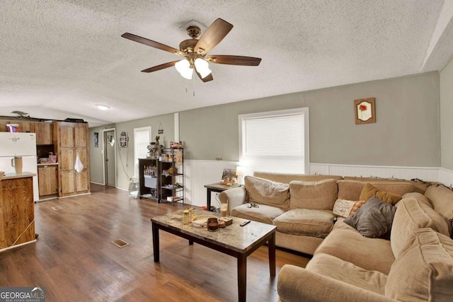 living room with a textured ceiling, dark wood-type flooring, ceiling fan, and lofted ceiling