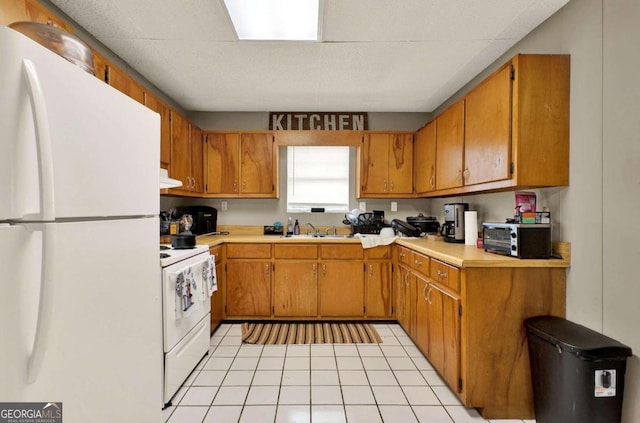 kitchen featuring range hood, light tile patterned flooring, white appliances, and sink