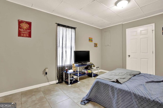 bedroom with a drop ceiling and light tile patterned flooring