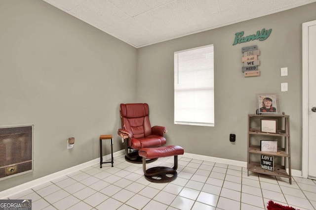 living area featuring heating unit and light tile patterned flooring