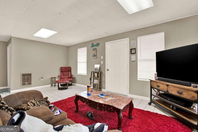 tiled living room with a paneled ceiling