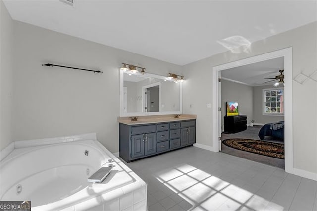 bathroom featuring tile patterned flooring, vanity, ceiling fan, and tiled bath