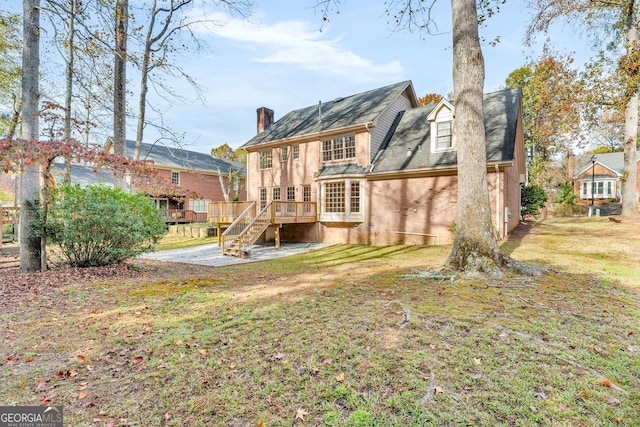 rear view of house with a lawn and a wooden deck