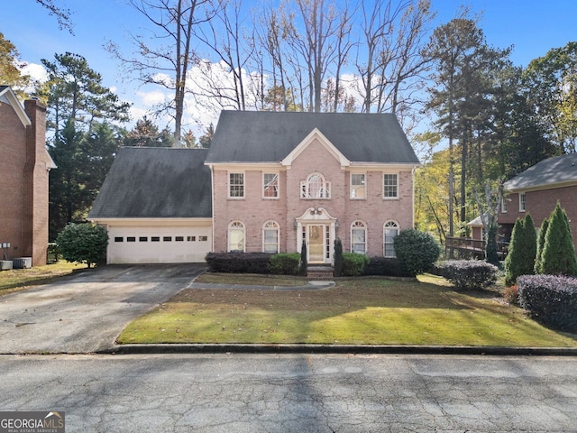 colonial-style house with a front yard and a garage