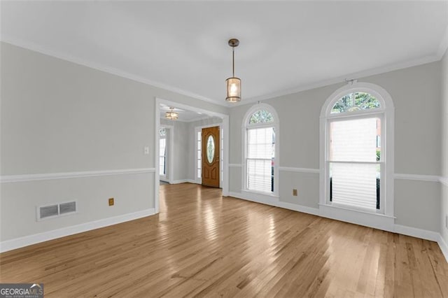 unfurnished room featuring crown molding and light wood-type flooring