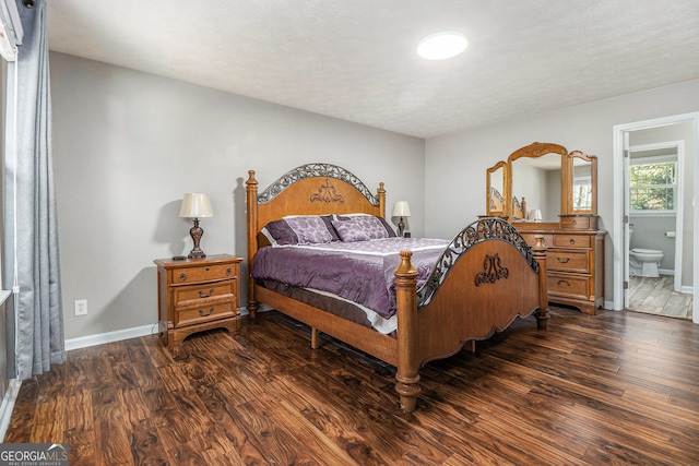 bedroom featuring dark wood-type flooring and ensuite bath