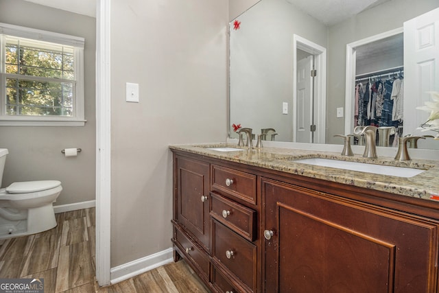 bathroom with wood-type flooring, vanity, and toilet