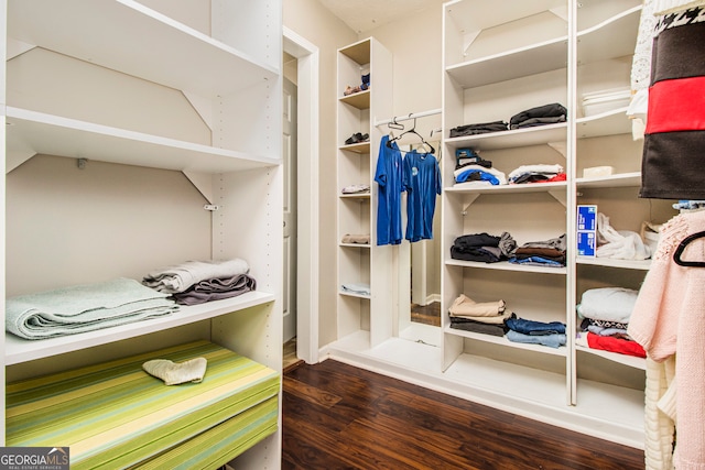 walk in closet with dark hardwood / wood-style floors