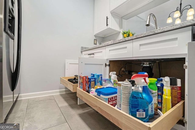 3655 Habersham Rd NE Unit 226-A, Atlanta, GA 30305 - detailed view of white cabinetry, baseboards, stainless steel fridge with ice dispenser, and light stone counters