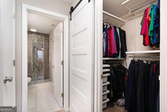 3655 Habersham Rd NE Unit 226-A, Atlanta, GA 30305 - walk in closet featuring a barn door and tile patterned flooring