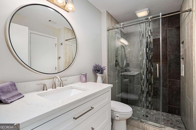 bathroom featuring vanity, toilet, and walk in shower