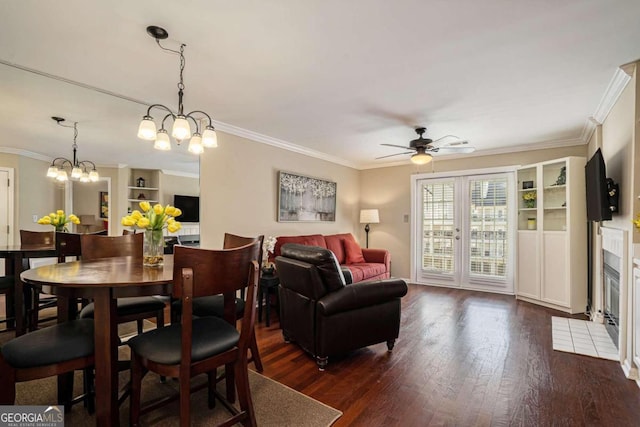 dining space featuring dark wood-type flooring, ceiling fan with notable chandelier, and ornamental molding