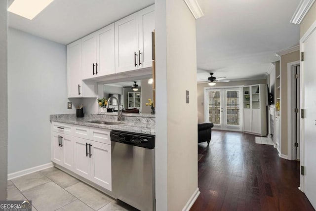 kitchen featuring sink, light hardwood / wood-style flooring, stainless steel dishwasher, light stone counters, and white cabinetry