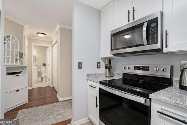 kitchen featuring dark hardwood / wood-style flooring, light stone counters, stainless steel appliances, crown molding, and white cabinets