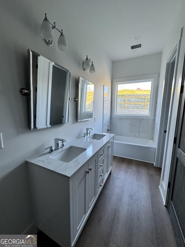 bathroom featuring vanity, a bath, and hardwood / wood-style floors