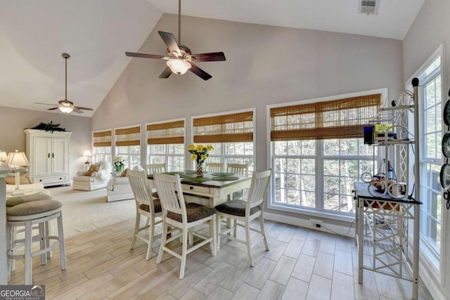 dining area featuring ceiling fan and high vaulted ceiling