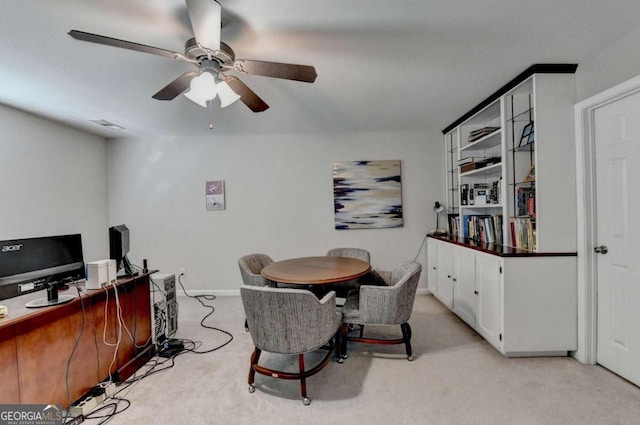 dining room with ceiling fan and light carpet