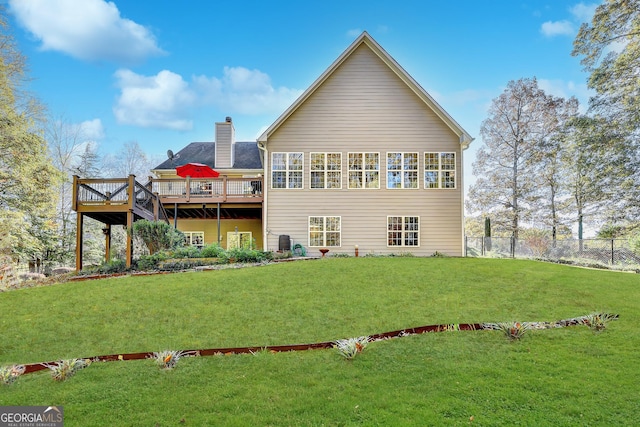 back of house featuring a deck and a lawn