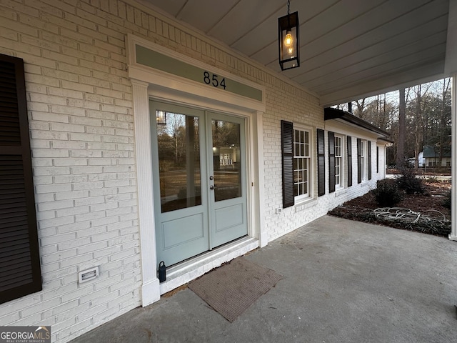 doorway to property featuring french doors and brick siding