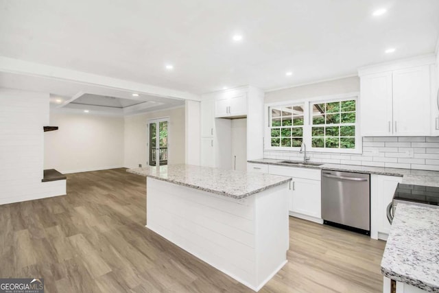 kitchen with white cabinetry, stainless steel dishwasher, and a center island