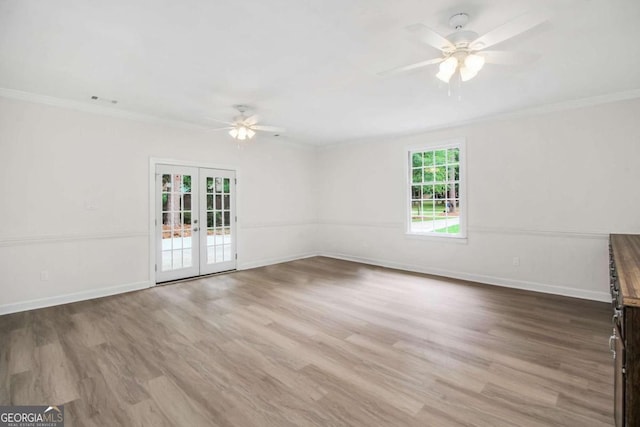 spare room featuring hardwood / wood-style flooring, ceiling fan, crown molding, and french doors