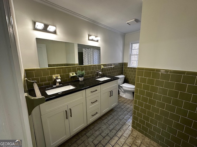 bathroom featuring visible vents, a sink, tile walls, and toilet