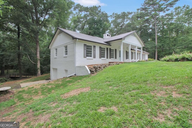 view of property exterior with covered porch and a lawn