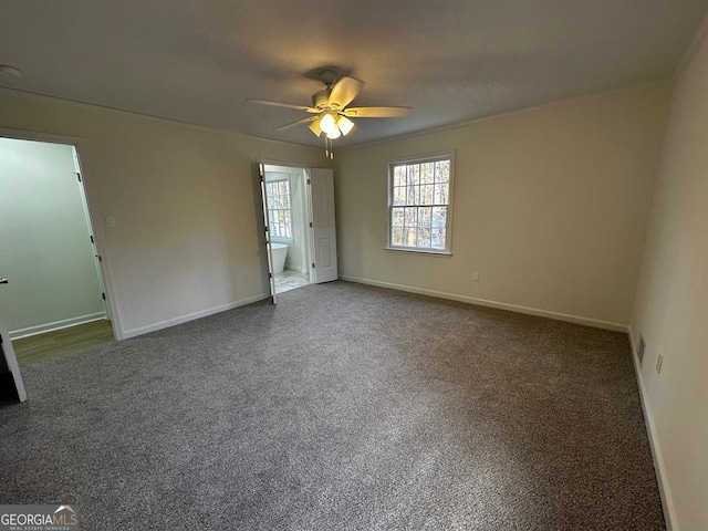 unfurnished bedroom with a ceiling fan, carpet, connected bathroom, and baseboards