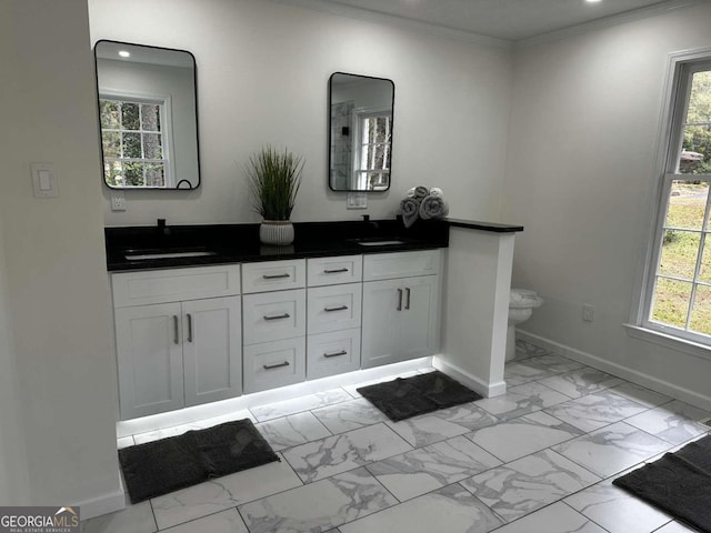 bathroom with baseboards, toilet, ornamental molding, marble finish floor, and a sink