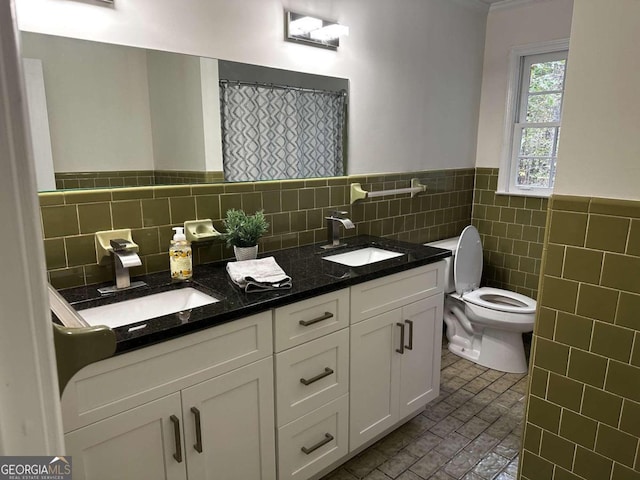 bathroom with toilet, vanity, and tile walls