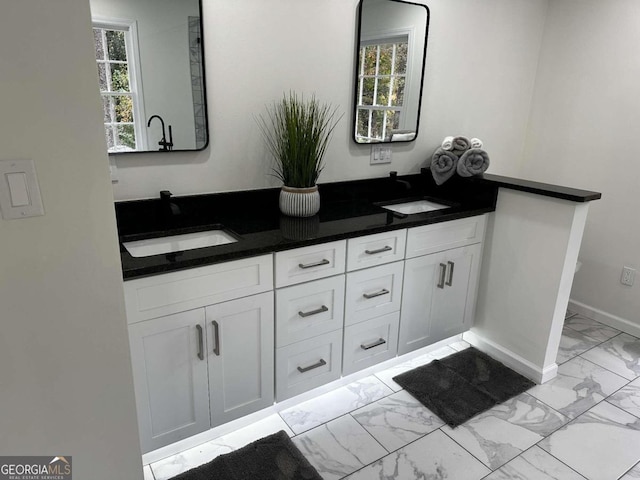 bathroom featuring marble finish floor, a wealth of natural light, and a sink