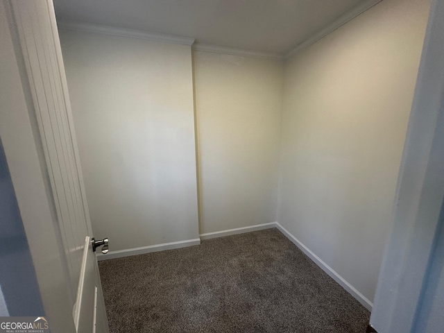 spare room with baseboards, dark carpet, and crown molding