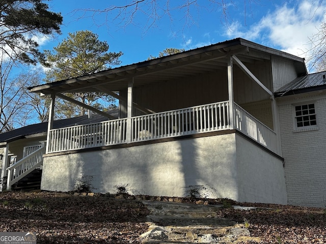 view of property exterior featuring metal roof and brick siding