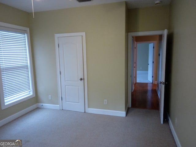 unfurnished bedroom with light colored carpet