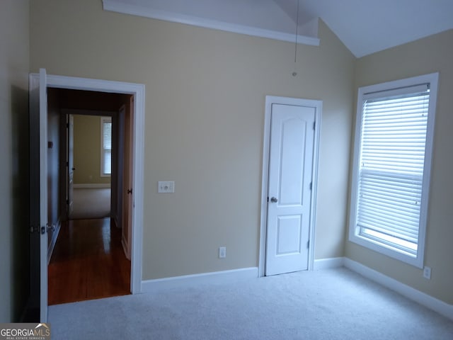 unfurnished bedroom with lofted ceiling and carpet floors