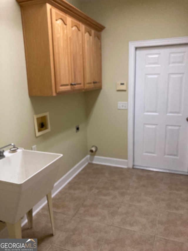 laundry area with hookup for an electric dryer, light tile patterned flooring, cabinets, and hookup for a washing machine