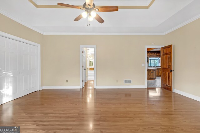 empty room with ceiling fan, wood-type flooring, and ornamental molding