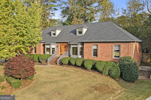 cape cod house with a front lawn