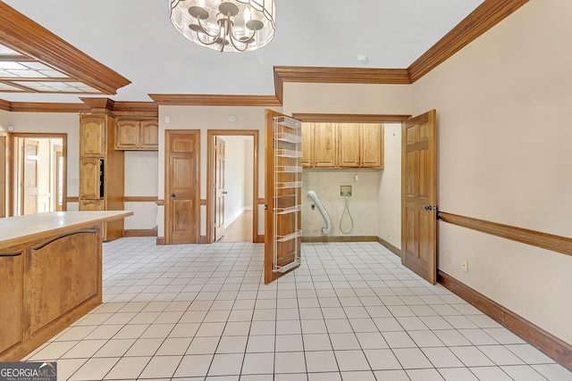 kitchen with a chandelier, light tile patterned flooring, baseboards, light countertops, and crown molding