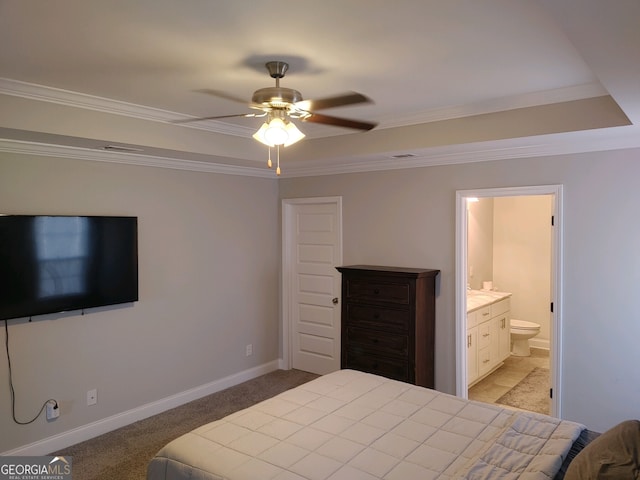 carpeted bedroom with ensuite bath, ceiling fan, and ornamental molding