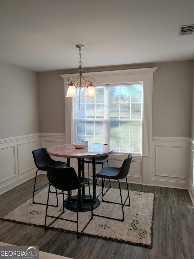 dining area with dark hardwood / wood-style flooring and a chandelier