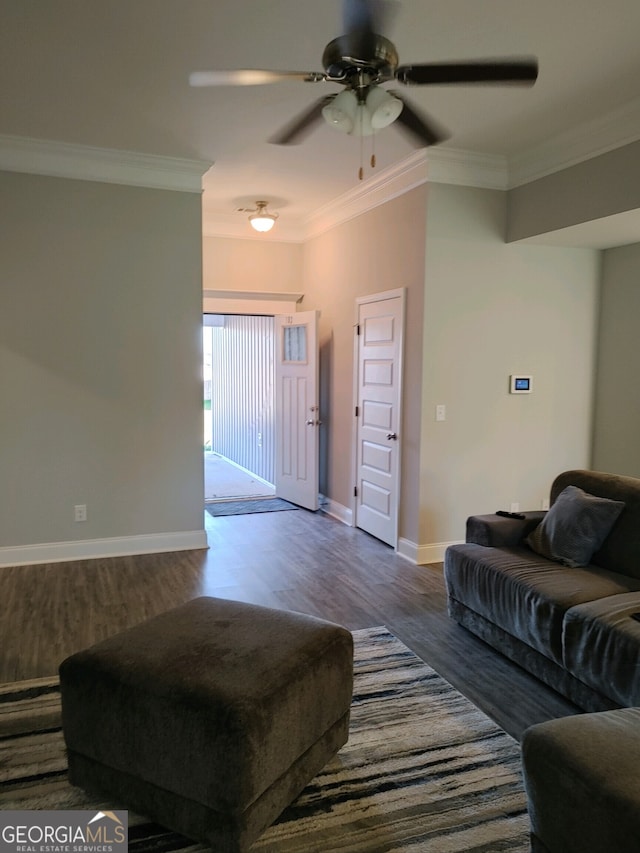 living room with crown molding, ceiling fan, and dark wood-type flooring