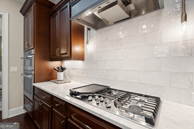 kitchen featuring decorative backsplash, light stone countertops, range hood, dark hardwood / wood-style flooring, and stainless steel appliances