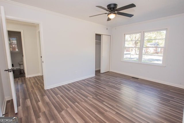 unfurnished bedroom featuring a closet, ceiling fan, crown molding, and dark wood-type flooring