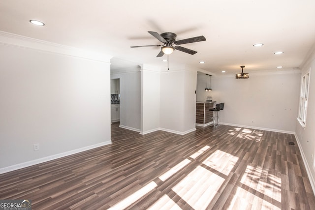 unfurnished living room featuring ceiling fan, dark hardwood / wood-style flooring, and ornamental molding