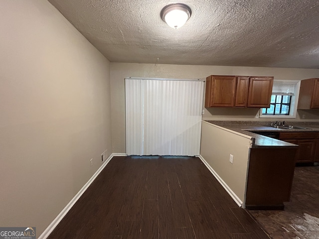 kitchen featuring a textured ceiling and dark hardwood / wood-style floors