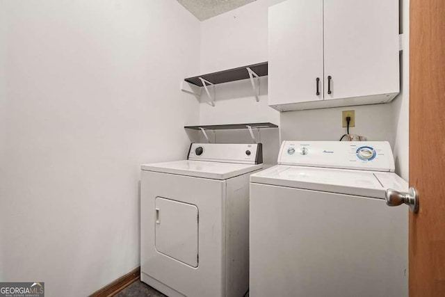 clothes washing area with cabinets, separate washer and dryer, and a textured ceiling