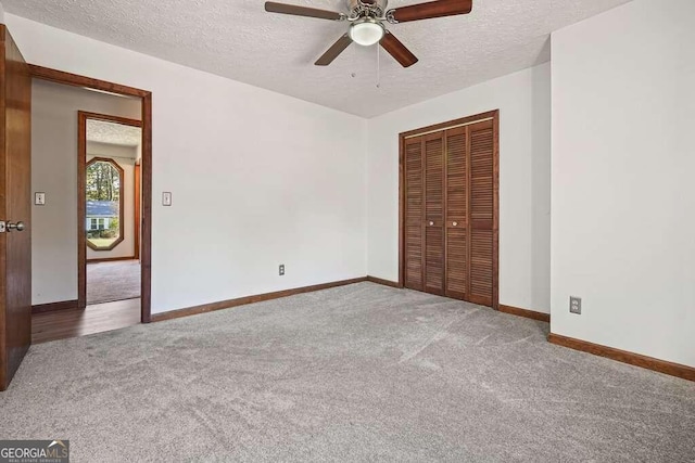 unfurnished bedroom with carpet, a textured ceiling, a closet, and ceiling fan