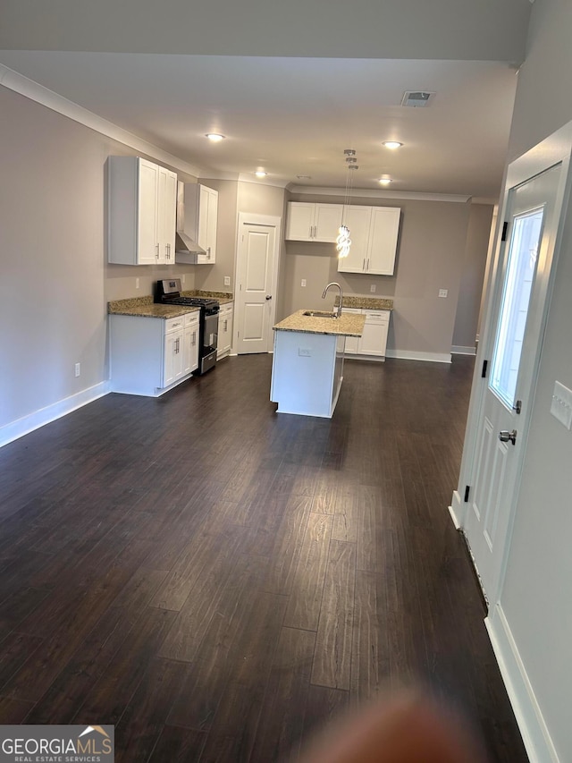 kitchen with white cabinets, dark hardwood / wood-style floors, an island with sink, decorative light fixtures, and gas stove