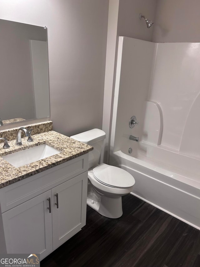 full bathroom featuring vanity, hardwood / wood-style flooring, toilet, and tub / shower combination